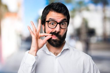 Yakışıklı adamla yapım sessizlik jest odaklanmamış arka plan üzerinde gözlük