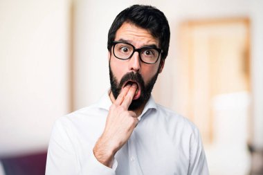 Yakışıklı adam gözlüklü odaklanmamış arka plan üzerine kusma jest yapma