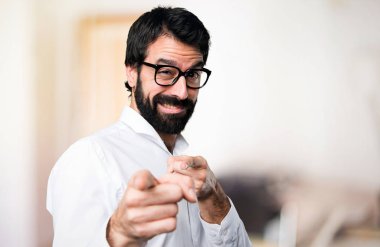 Gözlüklü odaklanmamış arka plan üzerine açık işaret eden yakışıklı adam