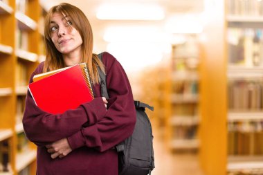 Öğrenci kadın odaklanmamış arka plan üzerinde önemsiz jest yapma