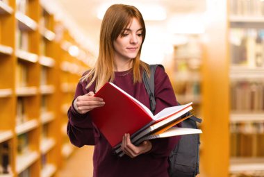 Öğrenci kadın odaklanmamış arka plan üzerinde kitap okuma