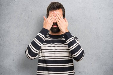 Gözlerinin üstüne dokulu arka plan kapsayan sakallı