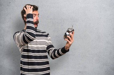 Vintage saat dokulu arka plan üzerinde tutarak sakallı şaşırmış adam