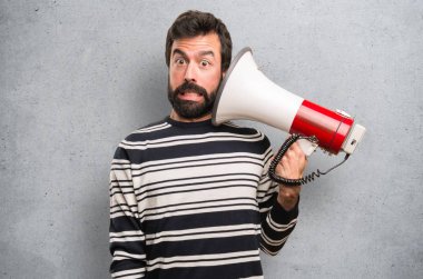 Sakallı bir megafon dokulu arka plan üzerinde tutan