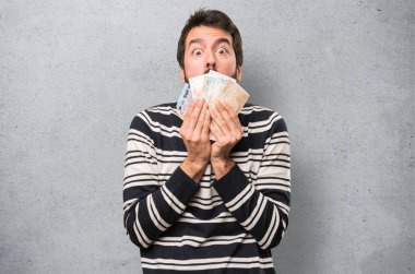 Dokulu arka plan üzerinde bir sürü para alarak sakallı