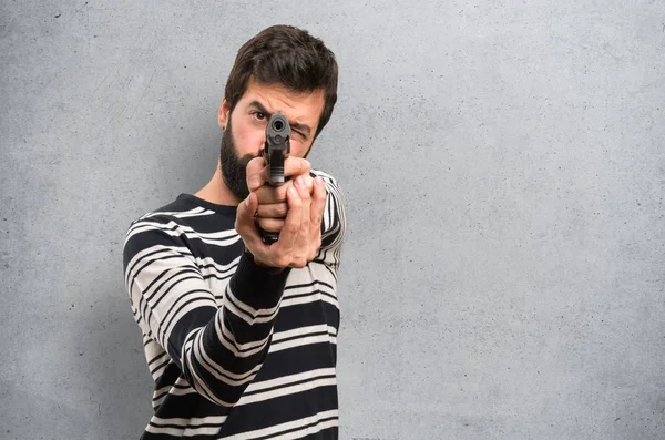 Homem Com Barba Atirando Com Uma Pistola Fundo Texturizado — Fotografia de Stock