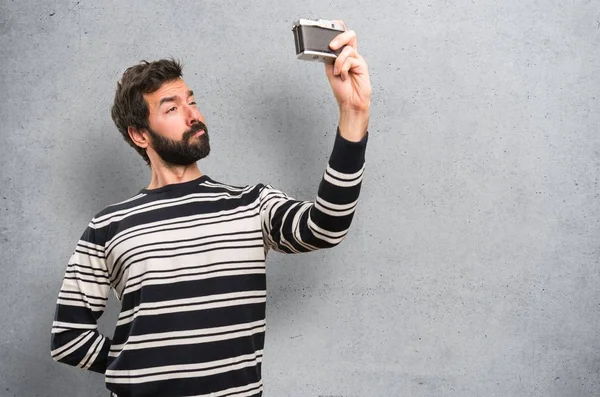 Homem Com Barba Segurando Uma Câmera Fundo Texturizado — Fotografia de Stock
