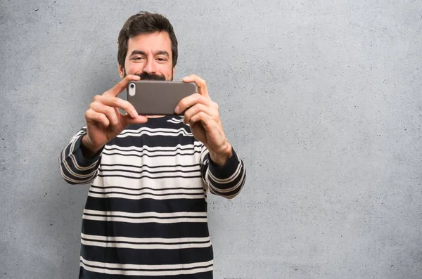 Mann Mit Bart Macht Selfie Auf Strukturiertem Hintergrund — Stockfoto