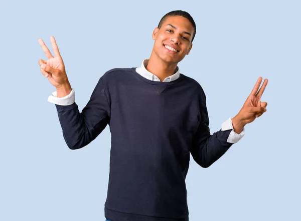 Молодий Афроамериканець Людиною Посміхаючись Показуючи Знак Перемоги Ізольованих Синьому Фоні — стокове фото