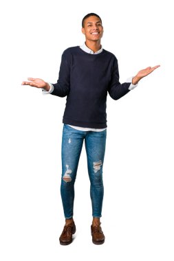 İzole beyaz arka plan üzerinde tatlı bir ifade ile gülümseyen genç Afro-Amerikan adam