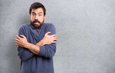 Dokulu arka plan üzerinde dondurma ile sakallı yakışıklı esmer adam