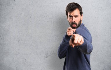 Dokulu arka plan ön işaret eden sakallı yakışıklı esmer adam