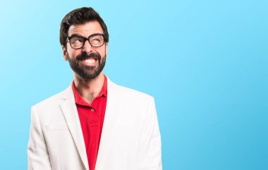 Renkli arka plan üzerinde önemsiz jest yapma gözlüklü esmer adam