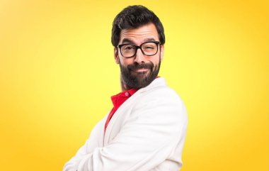 Kollarını ile gözlüklü esmer adam renkli arka plan üzerinde çarpı işareti