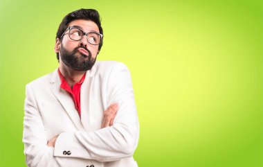 Renkli arka plan üzerinde önemsiz jest yapma gözlüklü esmer adam