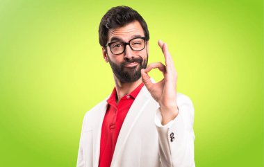 Renkli arka plan üzerinde oturum tamam yapma gözlüklü esmer adam