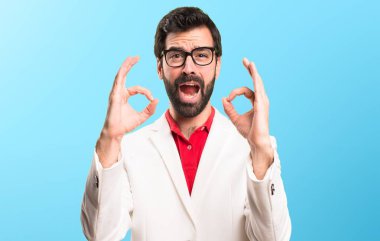 Renkli arka plan üzerinde oturum tamam yapma gözlüklü esmer adam