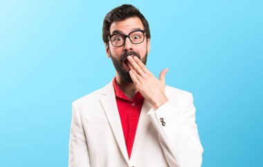 Esmer adam yapma sürpriz jest renkli arka plan üzerinde gözlük