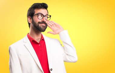 Renkli arka plan üzerinde bir şey dinlerken gözlüklü esmer adam