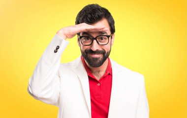 Bir şey renkli arka plan üzerinde gösterilen gözlüklü esmer adam