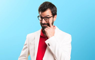 Bir şey renkli arka plan üzerinde gösterilen gözlüklü esmer adam