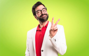 Esmer adam yapma zafer jest renkli arka plan üzerinde gözlük