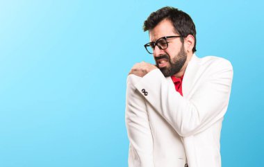 Renkli arka plan üzerinde omuz ağrısı ile gözlüklü esmer adam