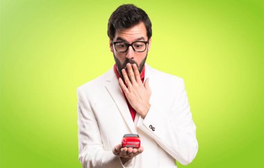 Şaşırmış esmer adam gözlüklü küçük araba renkli arka plan üzerinde tutan