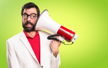 Bir megafon renkli arka plan üzerinde tutarak gözlüklü esmer adam