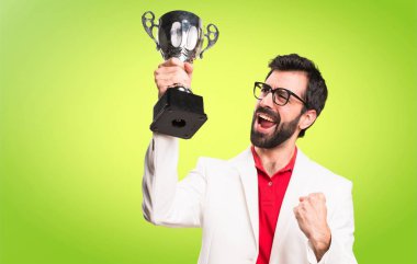 Gözlüklü bir kupa renkli arka plan üzerinde tutan mutlu esmer adam