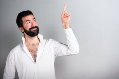 Gri arka plan üzerinde yukarıyı sakallı yakışıklı adam