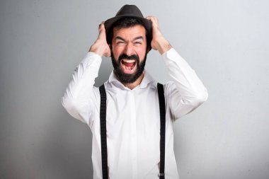 Gri arka plan üzerinde sakallı sinirli hipster adam
