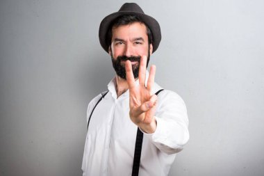 Üç gri arka plan üzerinde sayma sakallı hippi adam