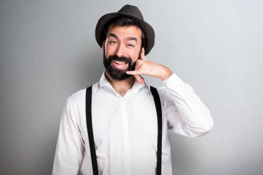 Hipster adam gri arka plan üzerinde sakal yapma telefon hareketi ile