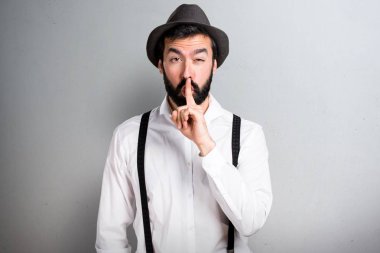 Hipster adam gri arka plan üzerinde sakal yapma sessizlik hareketi ile