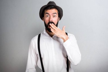 Gri arka plan üzerinde sakallı sürpriz hipster adam
