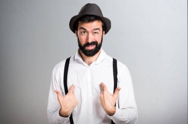 Gri arka plan üzerinde sakallı sürpriz hipster adam