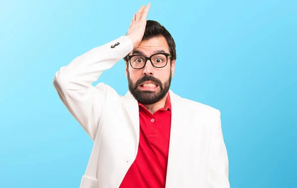 Brunette man with glasses having doubts on colorful background