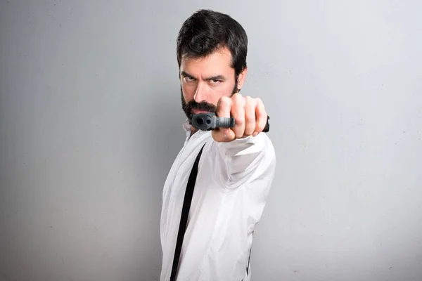 Hipster Uomo Tiro Con Una Pistola Sfondo Grigio — Foto Stock