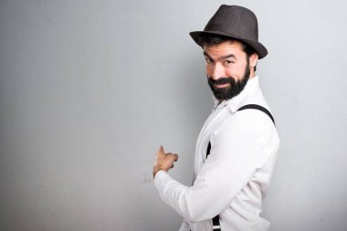 Gri zemin üzerine işaret eden sakallı hippi adam