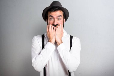Gri arka plan üzerinde sakallı korkmuş hipster adam