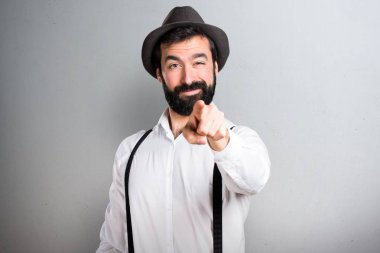 Gri arka plan üzerine açık işaret eden sakallı hippi adam