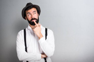 Hipster adam gri arka planı sakalını düşünce ile