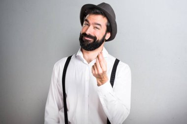 Hipster adam gri arka plan üzerinde sakal yapma para hareketi ile