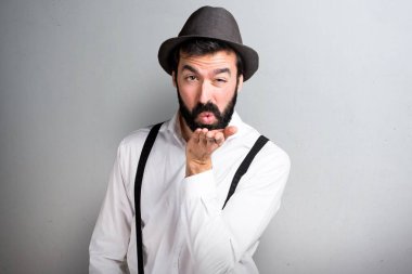 Gri arka plan üzerinde bir öpücük gönderme sakallı hippi adam