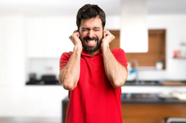 Yakışıklı adam kulakları evin içinde kapsayan