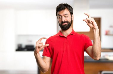 Yakışıklı adam evin içinde küçük işareti yapmak
