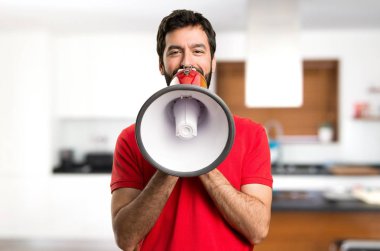 Yakışıklı adam evin içinde bir megafon holding