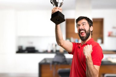 Evin içinde bir kupa tutan mutlu yakışıklı adam