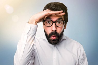 Gözlüklü bir şey mavi arka plan üzerinde gösterilen yakışıklı adam